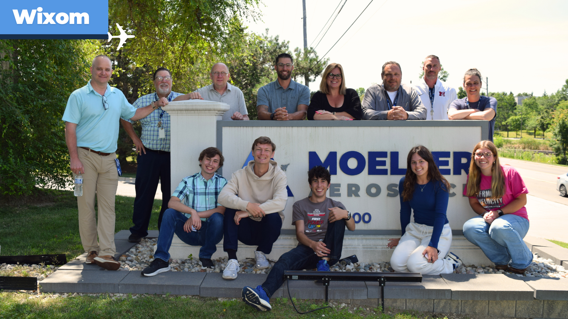 Wixom intern in front of Power BI dashboards, technical systems, and workstations inside the Moeller Aerospace IT department